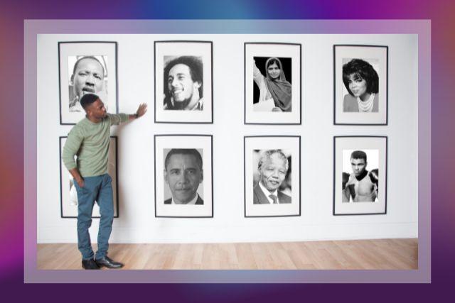 Image of Shaun Boothe standing next to framed photos hanging on a wall