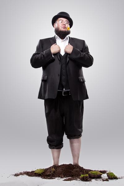 Shane Koyczan standing in dirt with flower